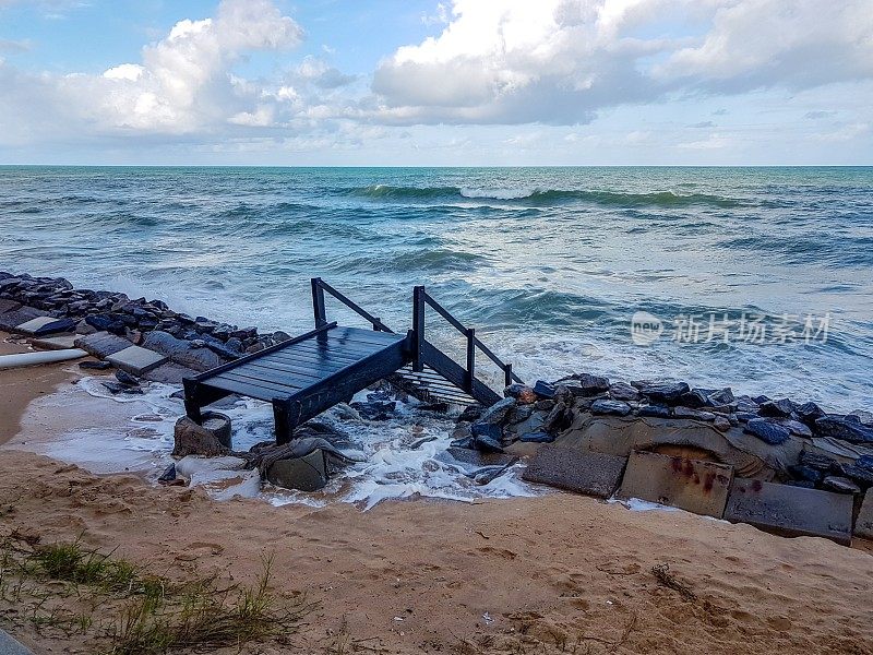 在巴西累西腓的Boa Viagem海滩，强大的蓝色海浪正向海浪块前进